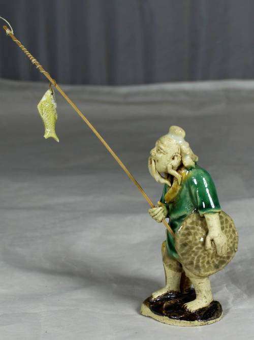 Mud Men - Old man holding a fish and hat