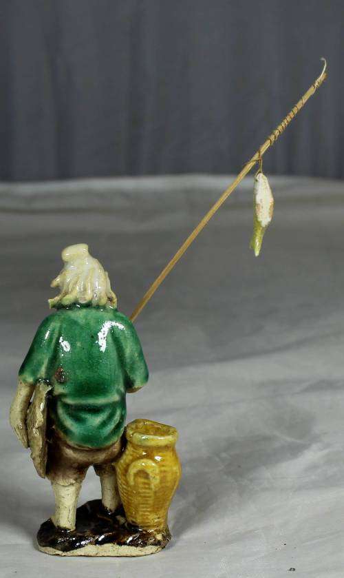 Mud Men - Old man holding a fish and hat