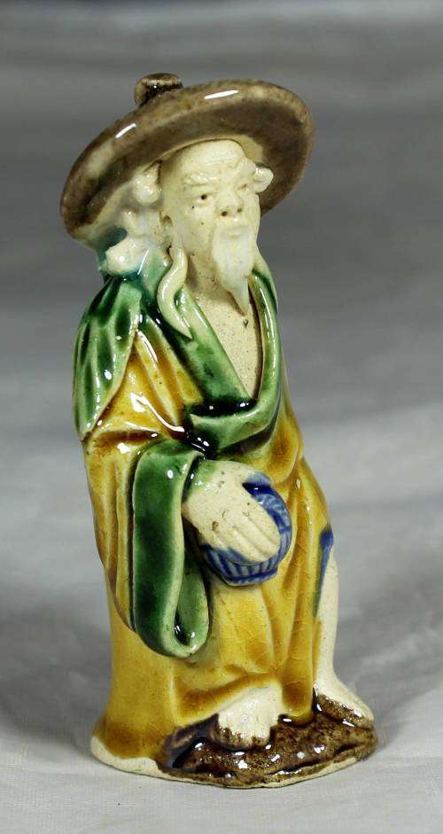 Mud men - old man holding a container