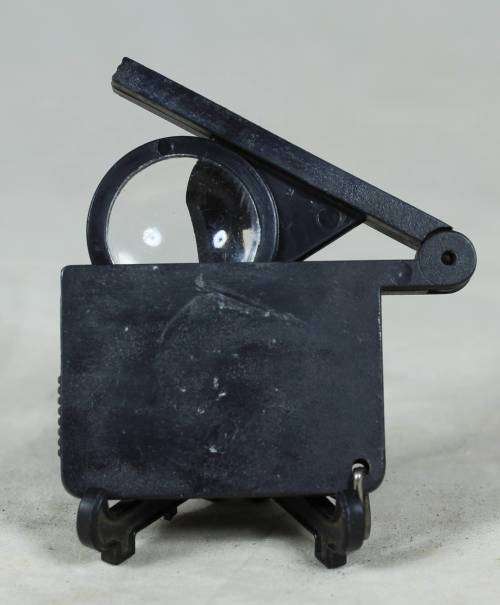 Miniature film clapper board with a magnifying glass