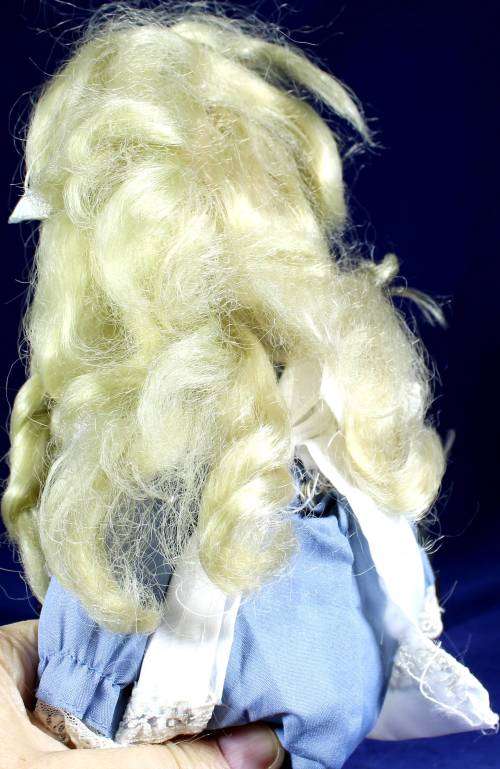 Porcelain doll - girl with pigtails in blue dress