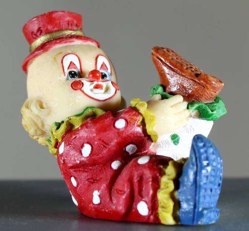 Small clown figurine kid putting on his shoe