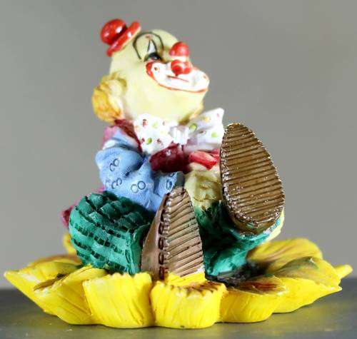 Small clown figurine seated on a sunflower