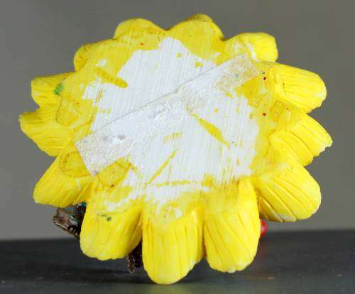 Small clown figurine seated on a sunflower