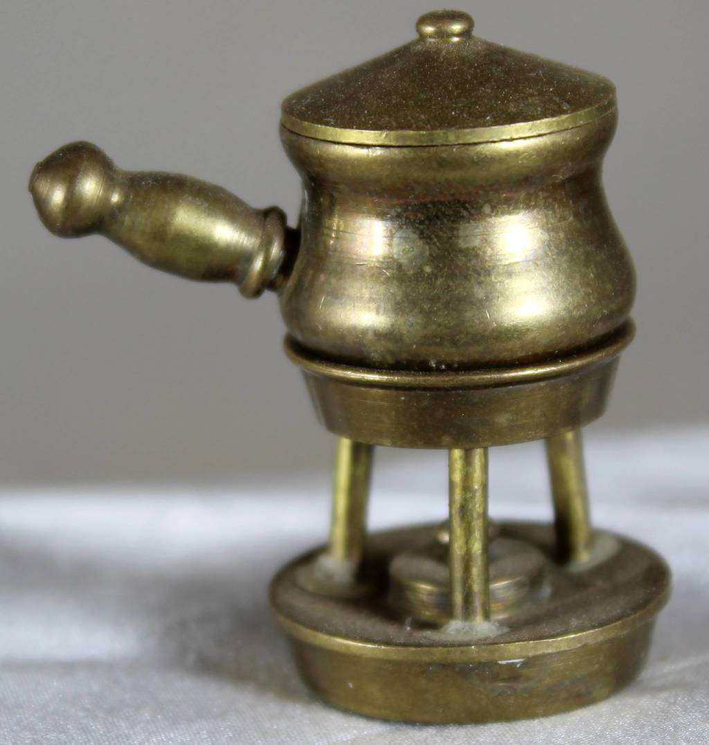 Miniature brass pot on gas burner