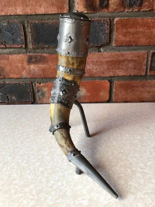 A pewter mounted powder horn with removable top, with engravings and embossed decoration