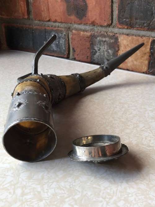A pewter mounted powder horn with removable top, with engravings and embossed decoration
