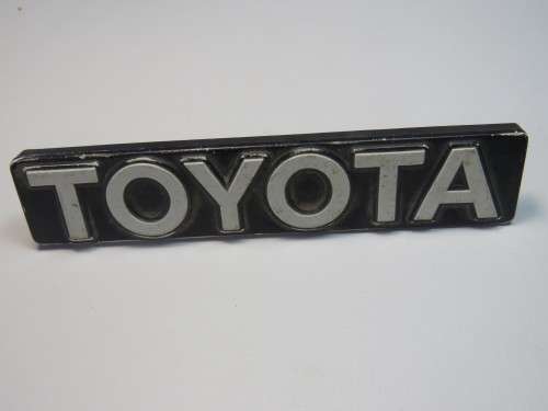 Toyota white on black plastic badge with pins