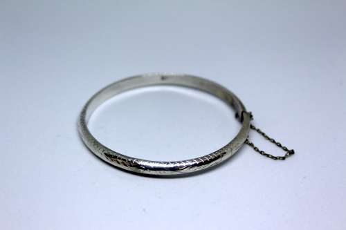 Vintage Sterling Silver Bangle with detail and safety chain. 20cm diametre
