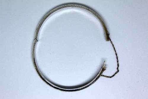 Vintage Sterling Silver Bangle with detail and safety chain. 20cm diametre