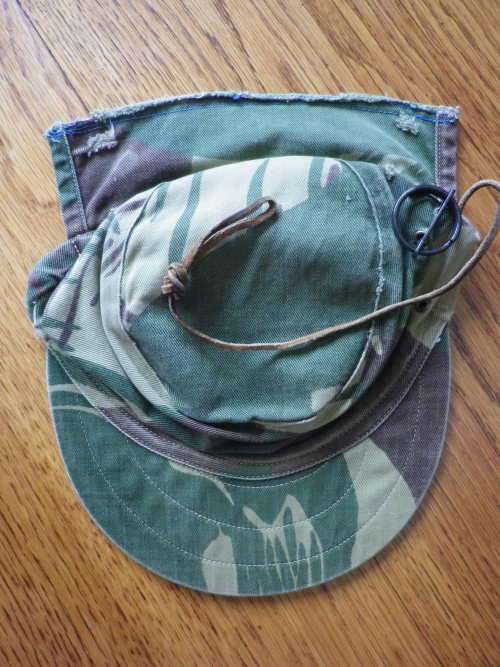 RHODESIAN -  CAMO CAP - PART OF FLAP CUT OFF BY OWNER - HAS ORIGINAL ORANGE LINING -  (5454)