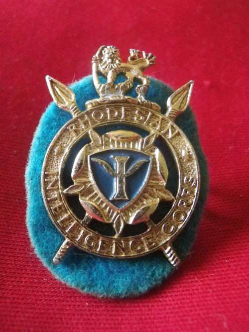 RHODESIAN INTELLIGENCE CORPS  - GOLD ANODISED + ENAMEL CAP BADGE WITH ORIGINAL FELT BACKING   (4660)