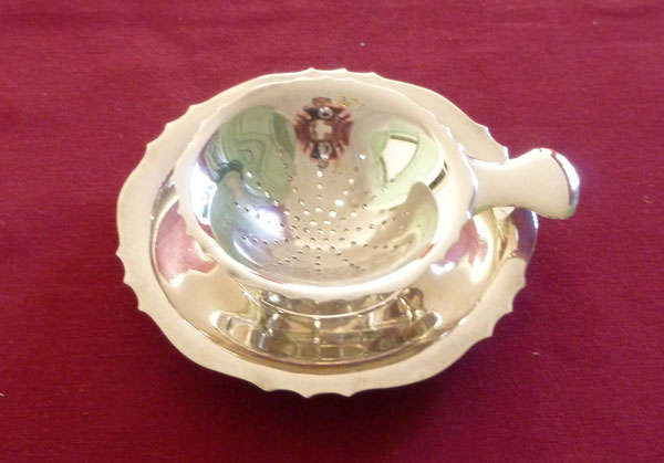 Silver plated tea strainer on stand