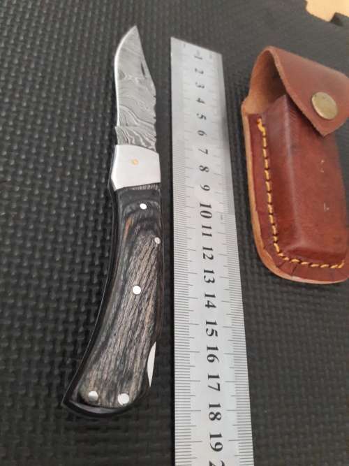 Handmade Damascus steel folding knife with Wooden handle scales.