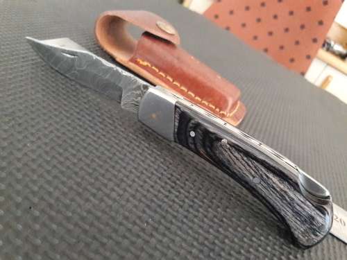 Handmade Damascus steel folding knife with Wooden handle scales.