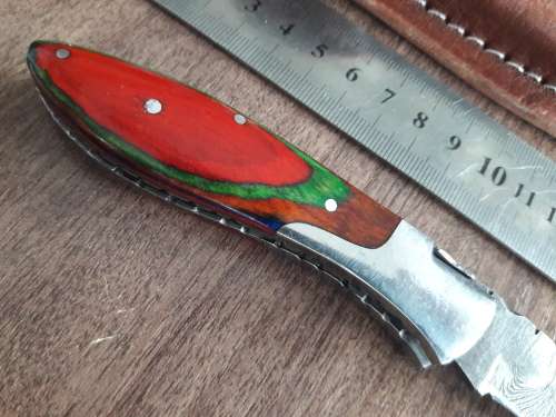 Handmade Damascus steel folding knife with Wooden handle scales.
