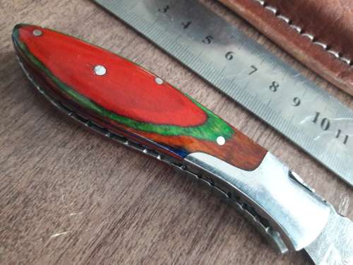 Handmade Damascus steel folding knife with Wooden handle scales.
