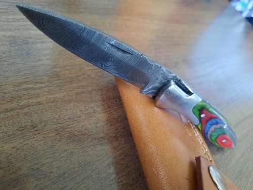 Handmade Damascus steel folding knife with Wooden handle scales.