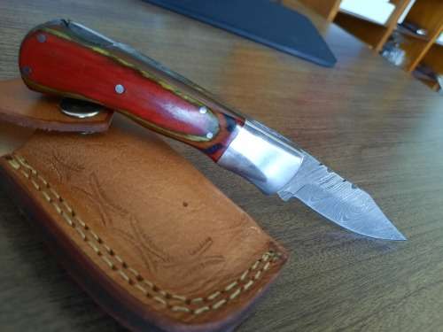 Handmade Damascus steel folding knife with Wooden handle scales.