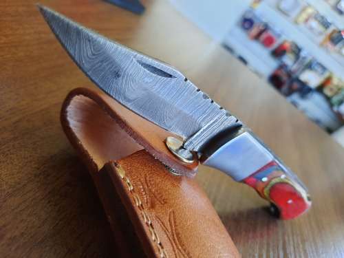 Handmade Damascus steel folding knife with Wooden handle scales.