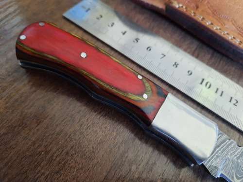 Handmade Damascus steel folding knife with Wooden handle scales.