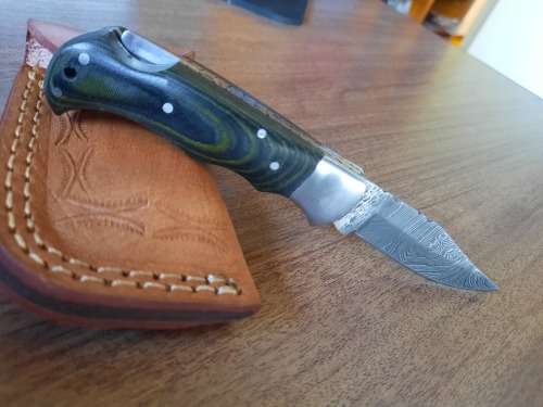 Handmade Damascus steel folding knife with MICARTA handle scales.