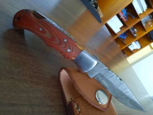 Handmade Damascus steel folding knife with MICARTA handle scales.