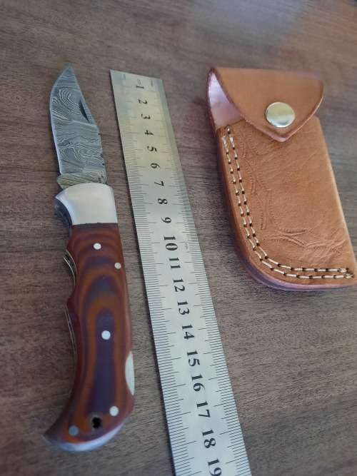 Handmade Damascus steel folding knife with MICARTA handle scales.