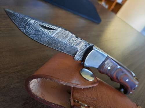 Handmade Damascus steel folding knife with MICARTA handle scales.