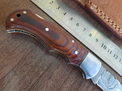 Handmade Damascus steel folding knife with MICARTA handle scales.