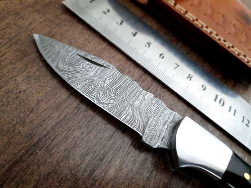 Handmade Damascus steel folding knife with Epoxy Resin handle scales. Leather pouch included.