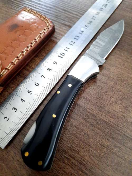 Handmade Damascus steel folding knife with Epoxy Resin handle scales. Leather pouch included.