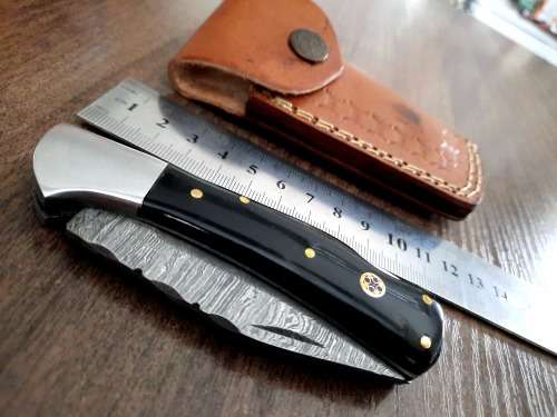 Handmade Damascus steel folding knife with Epoxy Resin handle scales. Leather pouch included.