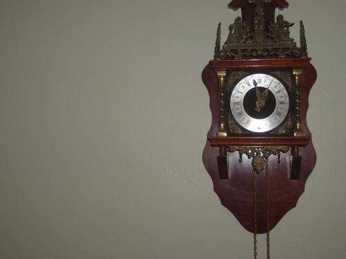 wooden wall clock with intricate brass detail. Made in Holland