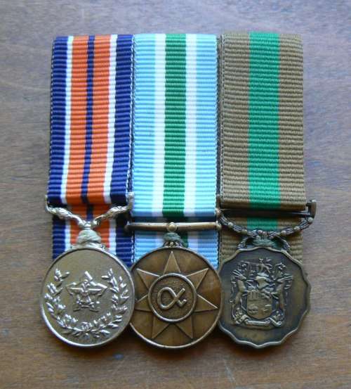 Lot of 3 miniature medals mounted with ribbons: Good Service, Unity & General Service