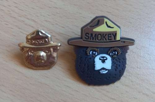 Pair of vintage Smokey Bear US lapel pin badges