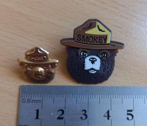 Pair of vintage Smokey Bear US lapel pin badges