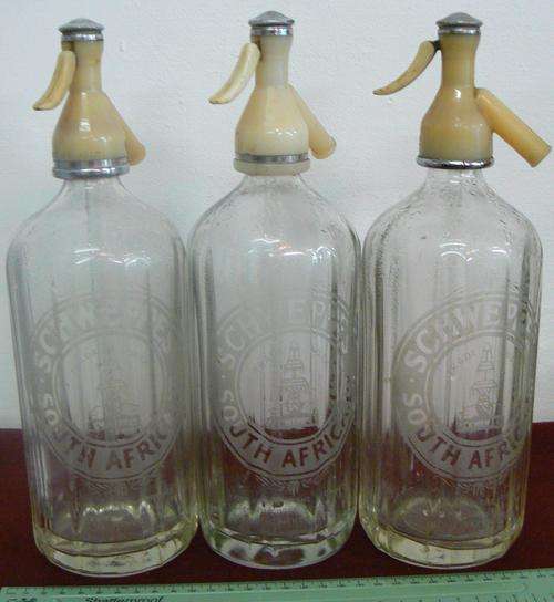 Three Schweppes soda bottles