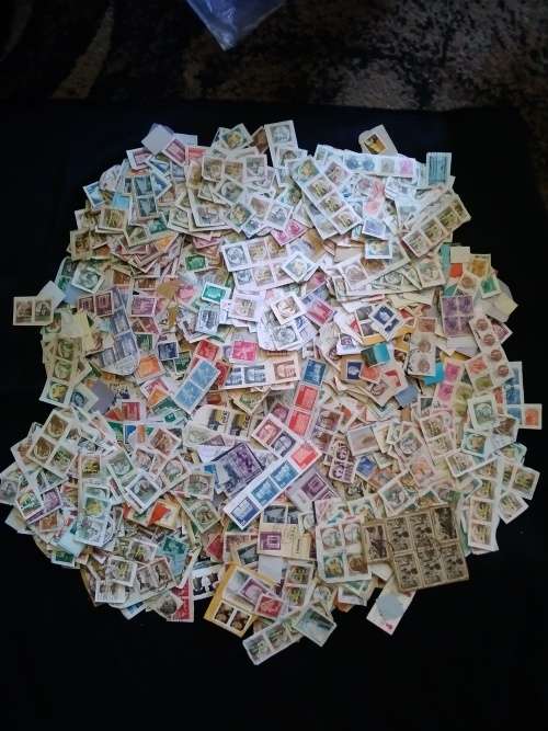 Worldwide. A mountain of used stamps on paper Unchecked. Duplications.