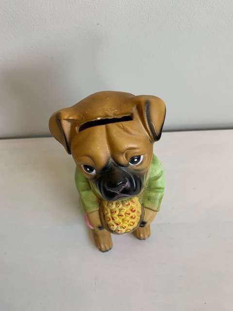 Large ceramic dog figurine that is also a piggy bank