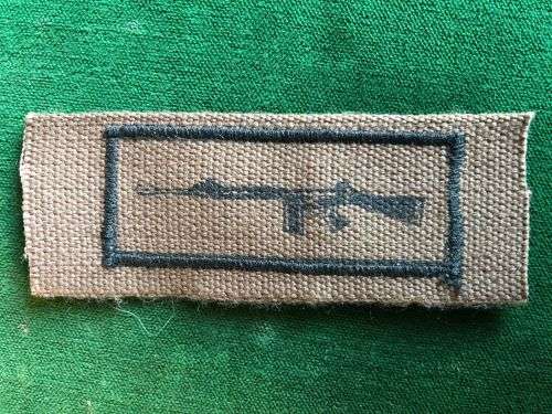 SADF PERIOD MARKSMAN BADGE PRINTED ON NUTRIA WITH EMBROIDERED BORDER AROUND RIFLE
