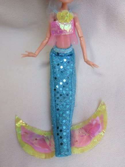 A PRETTY  CURLY HEADED FASHION DOLL IN MERMAID'S COSTUME