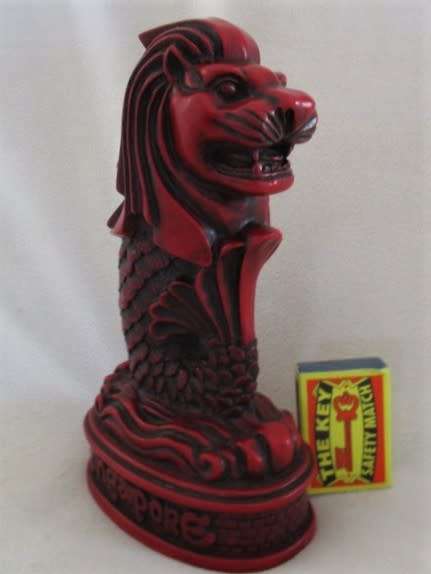 A SOLID RED RESIN PAPERWEIGHT FIGURINE OF SINGAPORE'S MYTHICAL MERLION