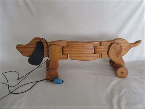 A VINTAGE 51CM LONG WOODEN DACHSHUND PULL-ALONG WITH MOVEABLE BODY