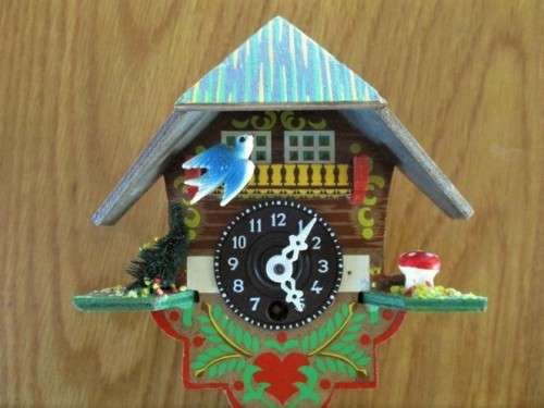 A SMALL VINTAGE NOVELTY CLOCK WITH GERMAN FRAULEIN ON SWING - WORKING???