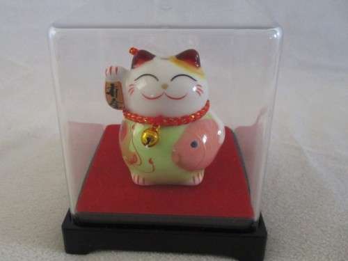 A CUTE CHINESE PORCELAIN MANEKI-NEKO (LUCKY CAT) IN PERSPEX BOX