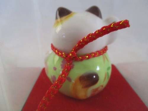 A CUTE CHINESE PORCELAIN MANEKI-NEKO (LUCKY CAT) IN PERSPEX BOX