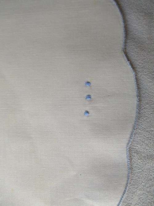 A SET OF TWO SMALL, ROUND VINTAGE HAND EMBROIDERED CLOTHS/DOILIES WITH LILY DESIGN