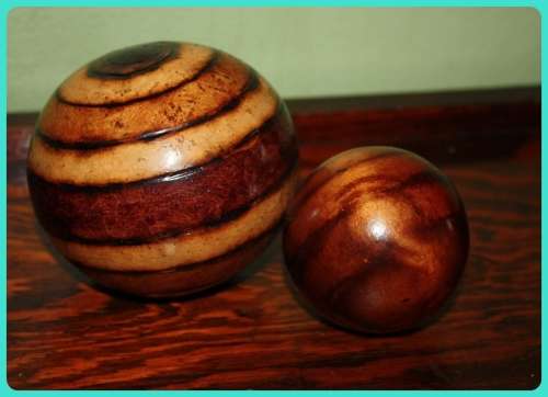 TWO WOODEN ORB DECORATIONS