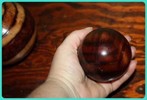 TWO WOODEN ORB DECORATIONS